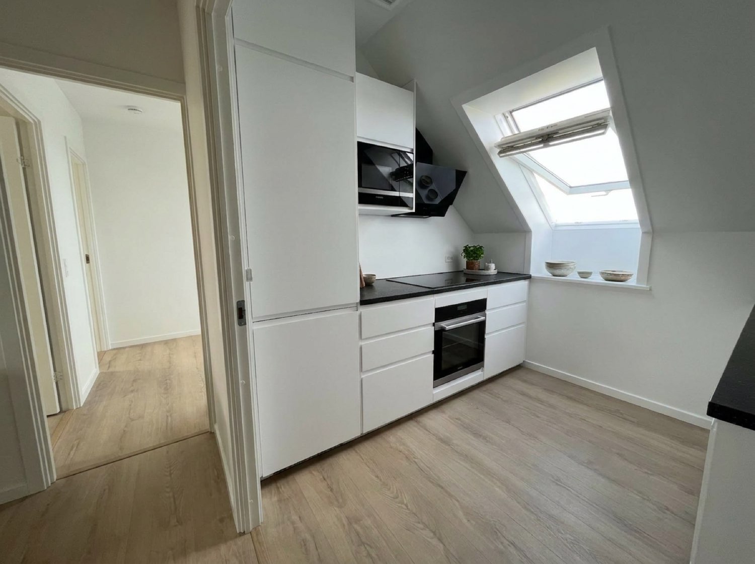 Lyst nyt køkken med hvide skabe og ovenlys efter køkkenmontering i Roskilde